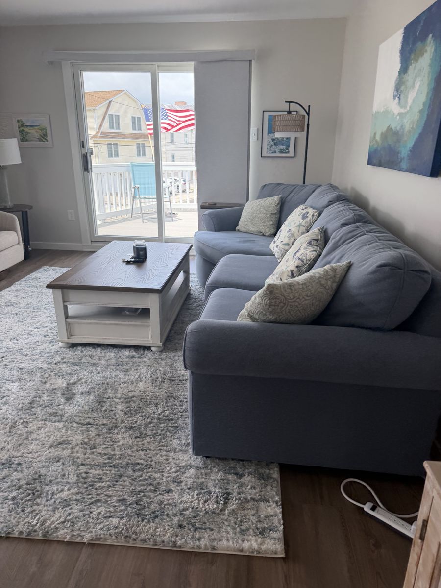 Living room staged with styled sectional and balcony view after turnover