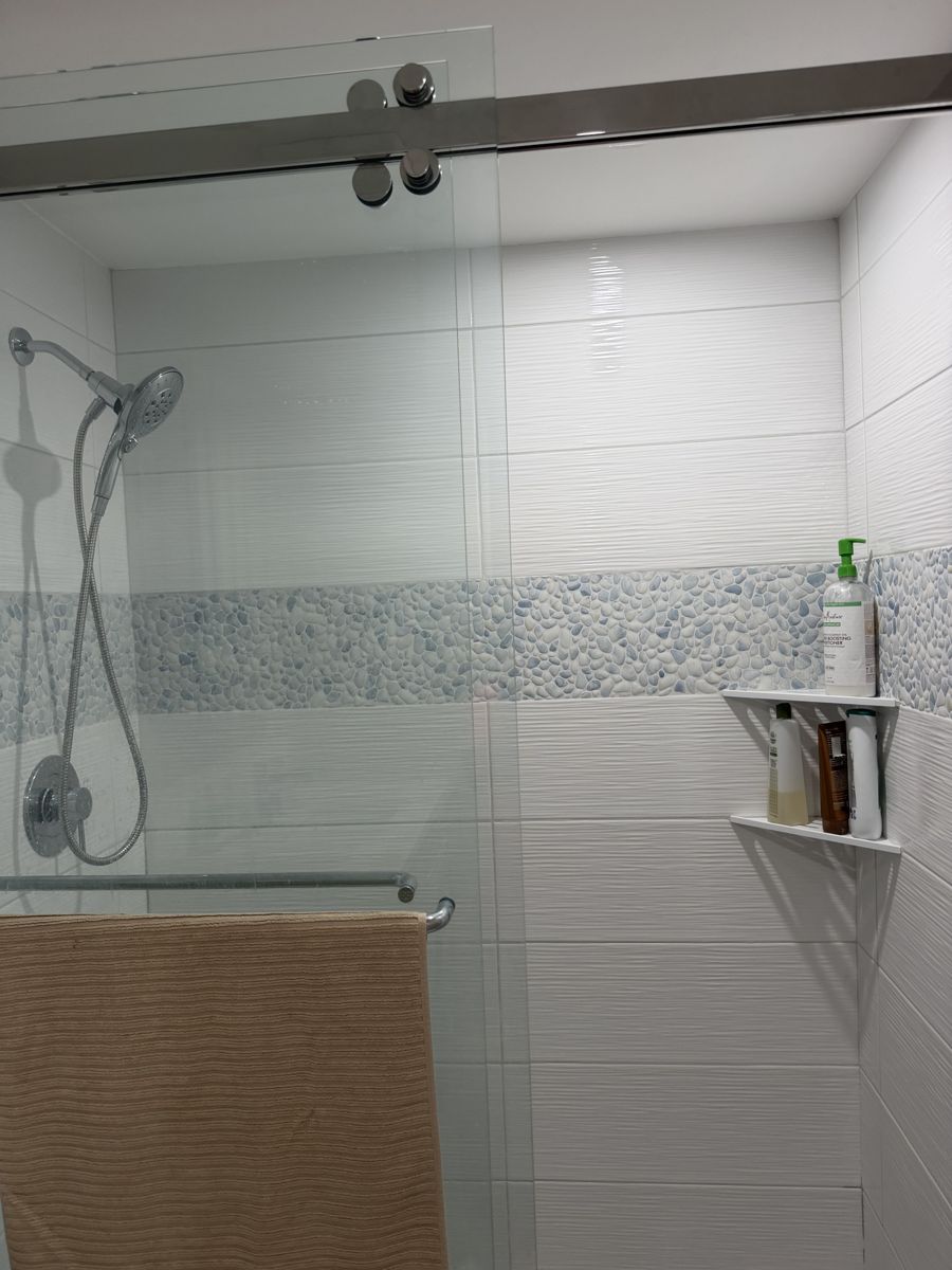 Glass shower cleaned with fresh towel styled on the bar