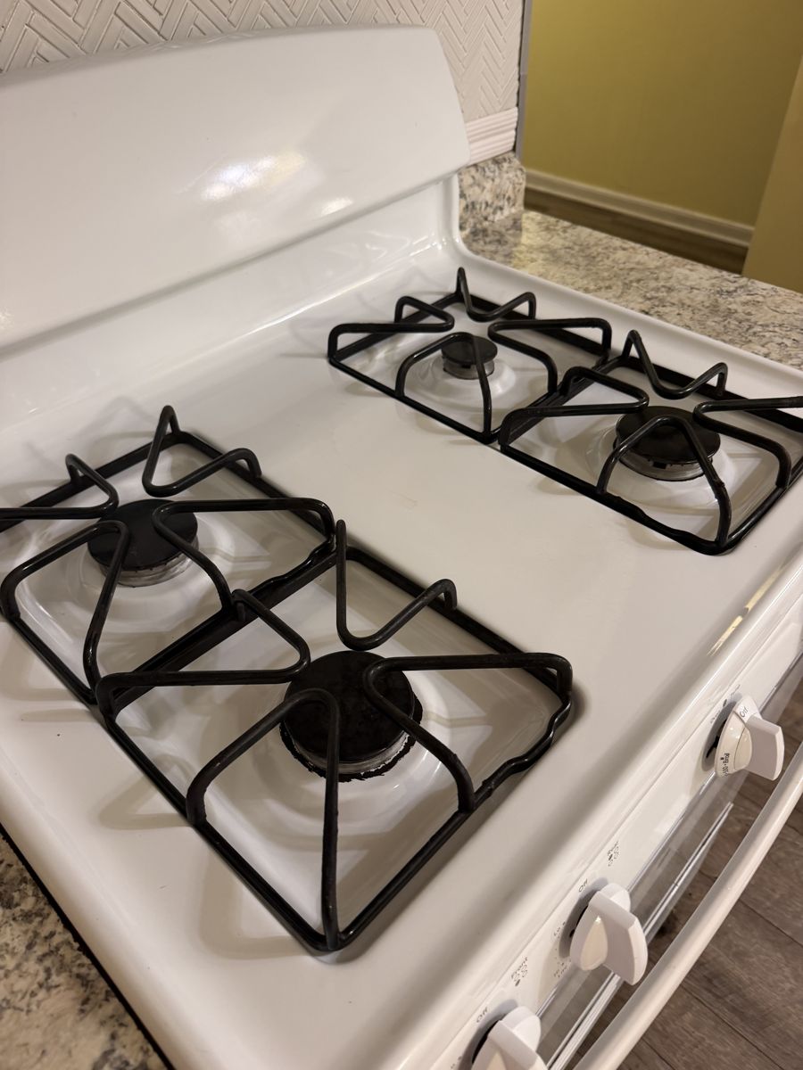 Stovetop burners and white enamel gleaming after cleaning