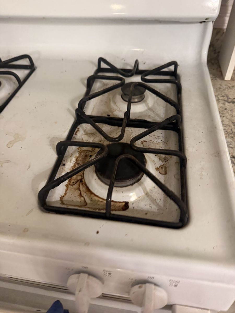 Stovetop burners stained with rust and grease before cleaning