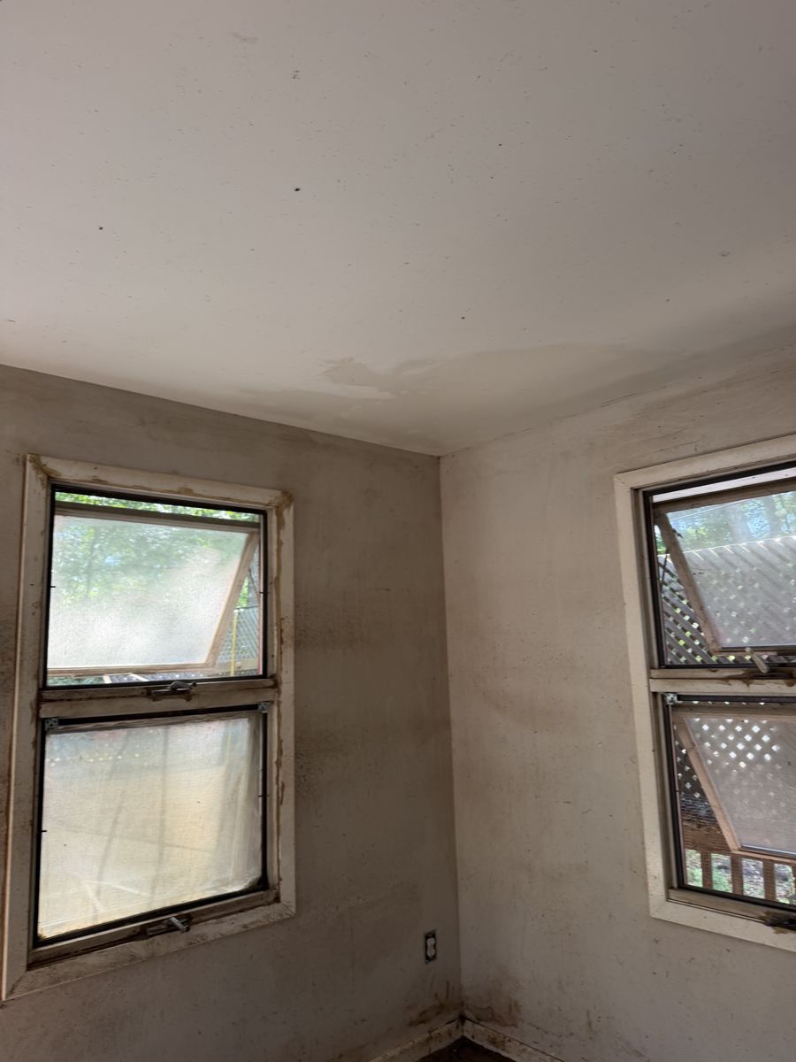 Laundry room window corner with stained walls before deep cleaning