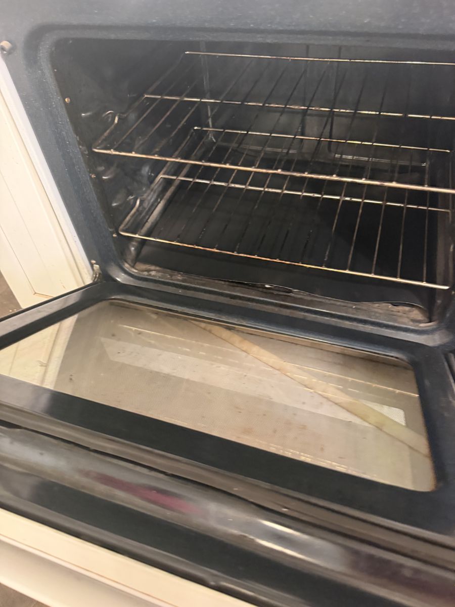 Oven interior with grime and dull glass before deep cleaning