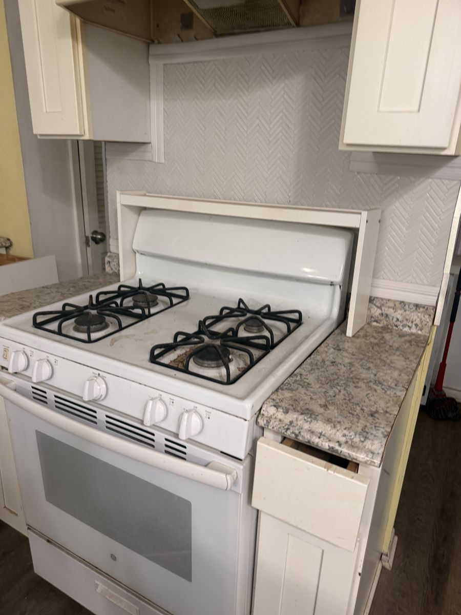 Gas range with grease and buildup before deep cleaning
