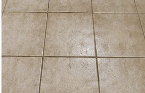 Tile floor with dirty grout before cleaning